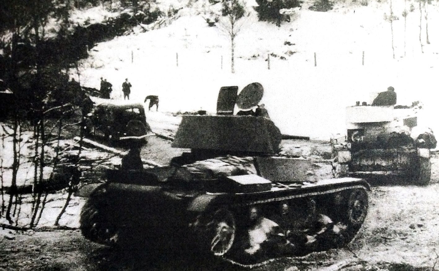 1939年11月底，「苏芬战争」期间，芬兰卡累利亚山谷，苏军一队T-26轻型坦克正在前进，走在前面的一辆是1939年款，而后一辆是1933年款，远处还有一辆「嘎斯M1」型人员运输车。