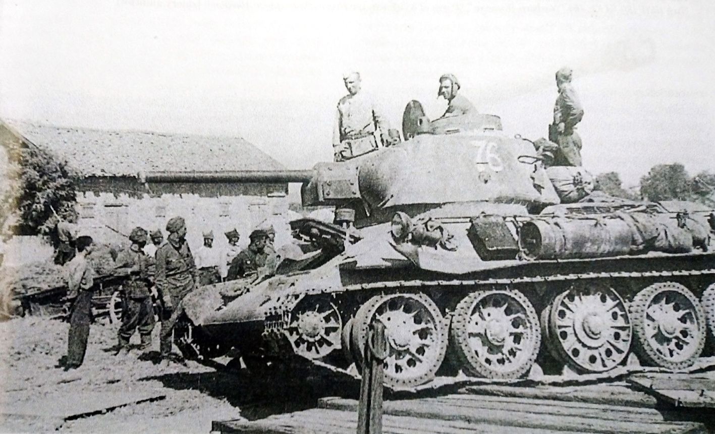 1943年8月，「库尔斯克会战」期间，东线苏联战场，一辆向哈尔科夫战场推进的苏军T-34/76坦克临时停靠在一个村庄旁。