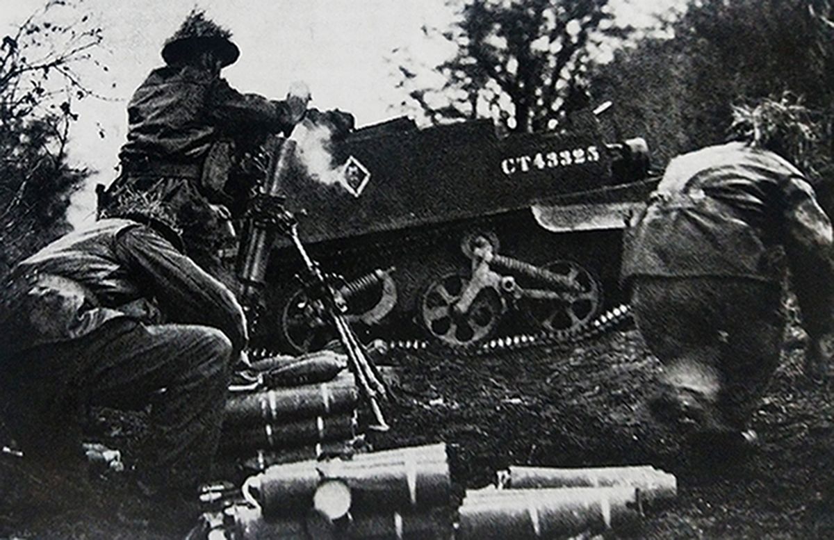 1944年夏天，「诺曼底战役」期间，西线法国战场，英军炮兵利用一辆履带运输车的车体作为掩护，用3英寸迫击炮向步兵提供火力支援。