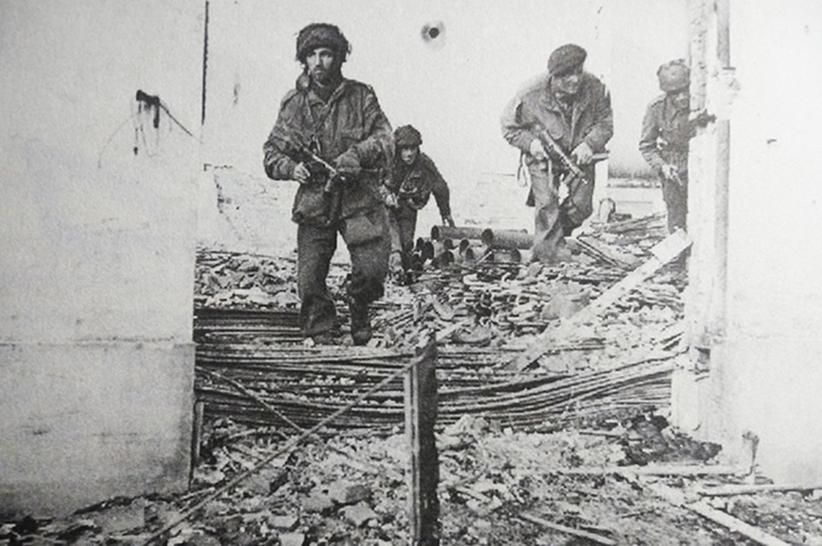 1944年9月,「市场花园行动」期间,西线荷兰战场,从安恒突出重围的英国第6空降师士兵手持「司登」MK5型冲锋枪,在奥斯特贝克的城市废墟中行进。