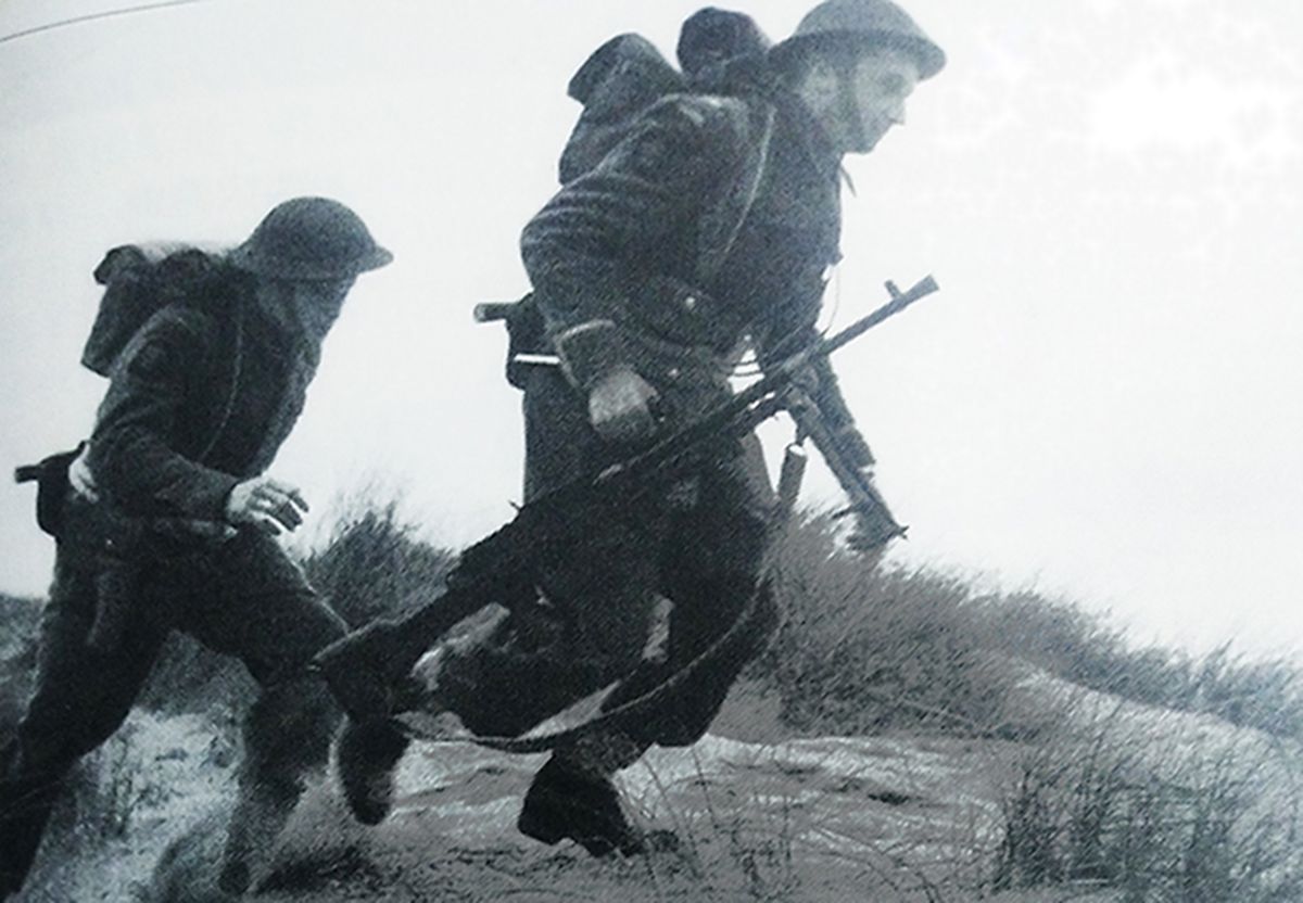 二战战场上，英军一个机枪组的士兵提着一挺「布伦」轻机枪作阵地转移。