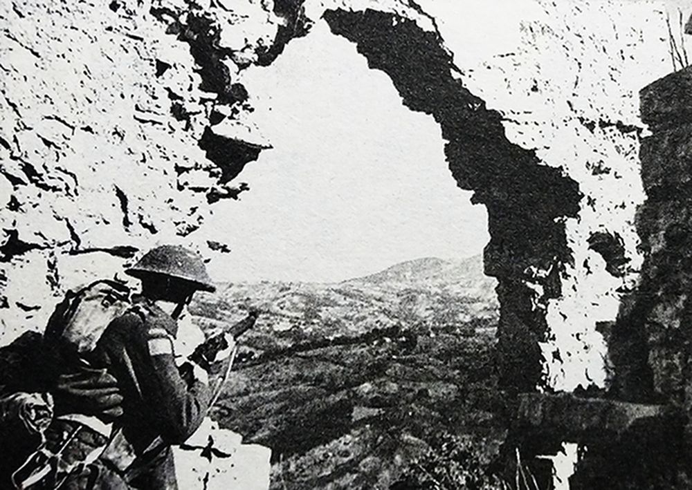 二战西线战场，一名手持「李-恩菲尔德」NO.1 MKⅢ型步枪的加拿大军士兵正在石墙洞内阻击德军进攻。