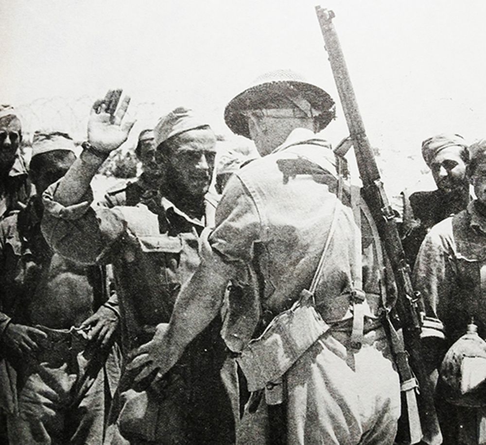 二战，「北非战役」期间，英国第8集团军一名背着「李-恩菲尔德」NO.1 MKⅢ型步枪的士兵正在收押意军俘虏。