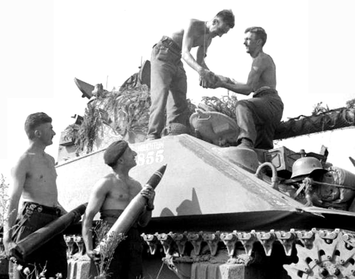 1944年法国战场,英军一辆「萤火虫」坦克的乘员正在给坦克装弹,作下次战斗的准备。