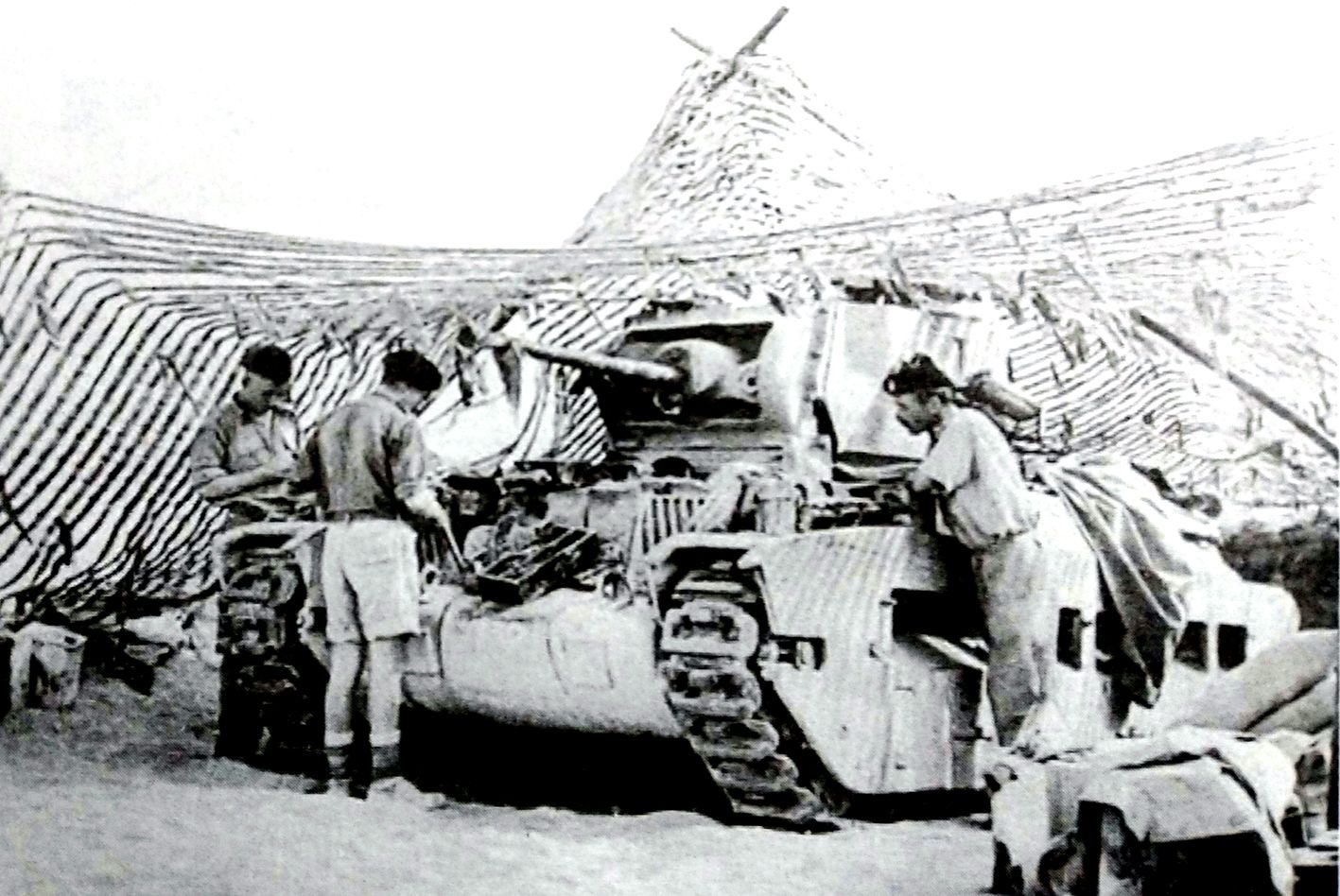 1941年,非洲战场,英军对一辆在伪装网内的马蒂尔达Ⅱ型步兵坦克进行检修。