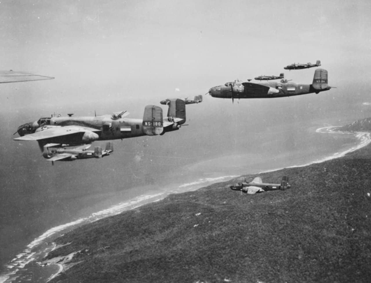 1943年,八架隶属于澳大利亚皇家空军(RAAF)第18(荷属东印度)中队的北美B-25「米切尔」轰炸机飞越达尔文附近的海岸上空。注意,这些飞机均带有荷属东印度(NEI)的注册编号与标识。