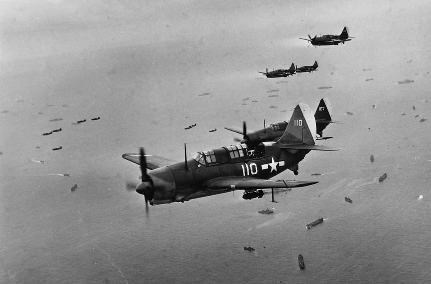 1945年2月22日,隶属于「约克城」号航空母舰(CV-10)第3航母航空大队下属第3轰炸机中队(VB-3)的柯蒂斯SB2C-4「地狱俯冲者」俯冲轰炸机,在对硫磺岛实施空袭期间飞越登陆舰队上空。请注意该机机身上标示的「约克城」号航母航空大队特有的几何形状识别符号。