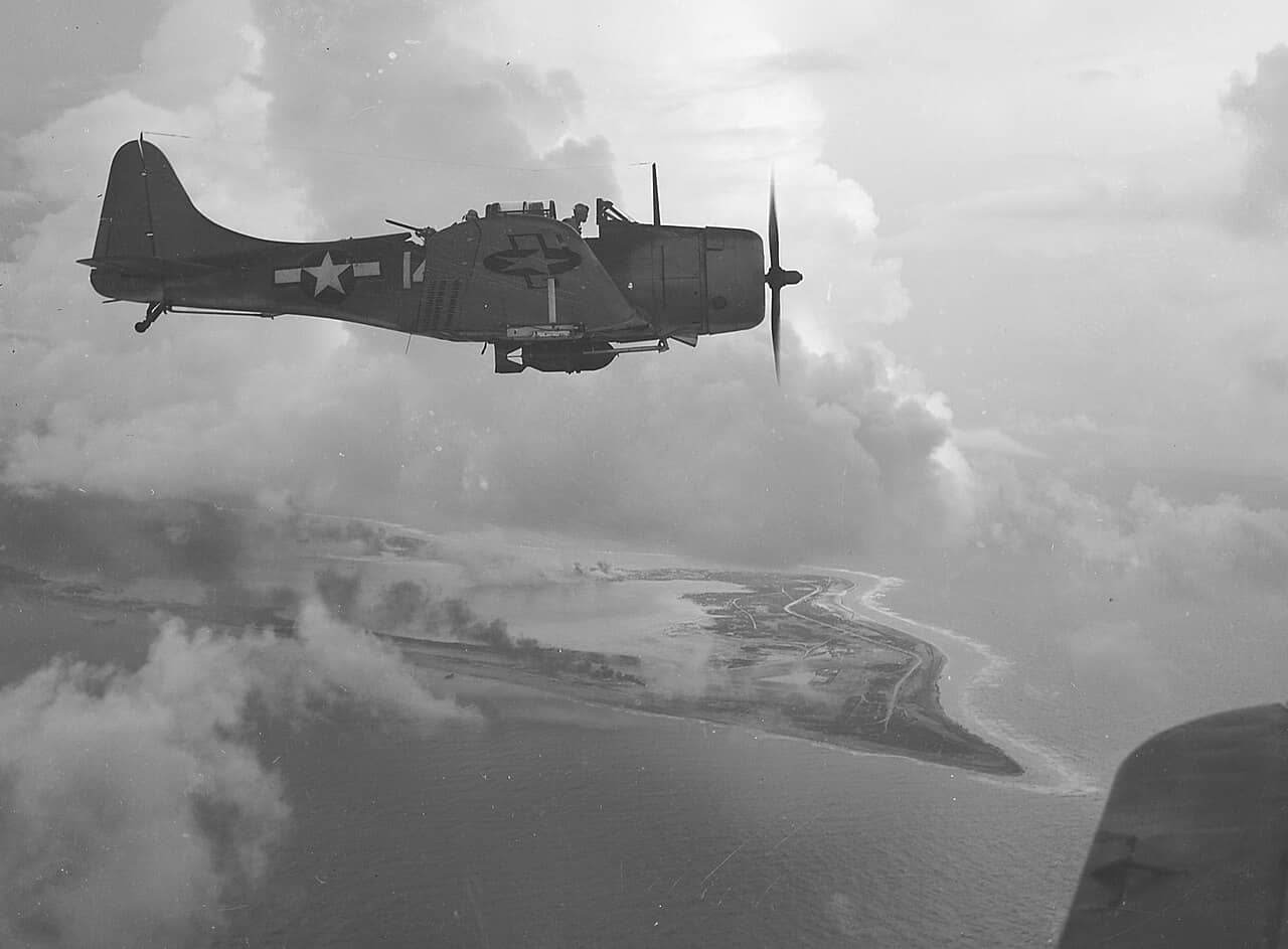 1943年10月初,来自「约克城」号(USS Yorktown, CV-10)的VB-5中队SBD-5「无畏」俯冲轰炸机飞越威克岛上空。注:1942年舷号 CV-5 的「约克城」号在「中途岛海战」中沉没后,美军将原本建造中(原拟命名为「好人理查德」号)的舷号 CV-10 航母改名为新的「约克城」号以作纪念。