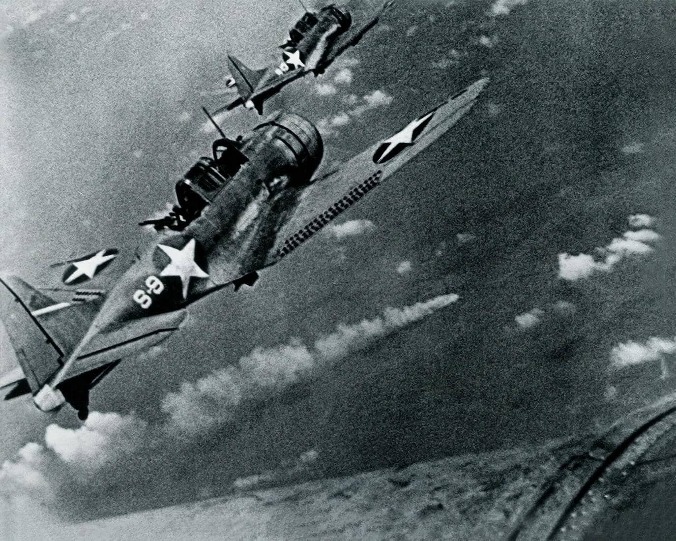 1942年6月6日,隶属于「大黄蜂」号(USS Hornet,CV-8)航母第8侦察中队(VS-8)的SBD-3「无畏」俯冲轰炸机飞越遭重创燃烧的日本「三隈」号重巡洋舰上空。该舰在「中途岛海战」中被美军舰载机反复攻击后沉没。