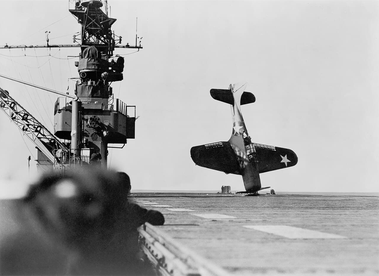 1943年6月21日,一架道格拉斯SBD-3「无畏」俯冲轰炸机在航母飞行甲板上紧急迫降后,机头触地呈倒立状。