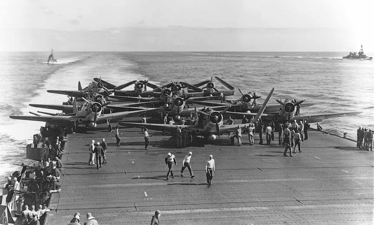 1942年6月4日,在「企业」号航空母舰(CV-6)甲板上准备起飞的美国海军VT-6鱼雷轰炸机中队。画面中可见从「企业」号起飞的14架TBD-1「毁灭者」中的11架。其中左前方的那架TBD-1「毁灭者」是2号机(海军序列号:BuNo 1512),由塞弗林·L·隆巴赫(Severin L. Rombach)少尉和二级航空无线电员 W.F. 格伦(W.F. Glenn)驾驶。在随后的两个多小时里,该机及其机组人员在攻击日本航空母舰的行动中与其他8架VT-6中队的飞机一同损失。远处右侧可见彭萨科拉号(USS Pensacola,CA-24)重巡洋舰,左侧则有一艘驱逐舰处于「飞机护卫」位置。