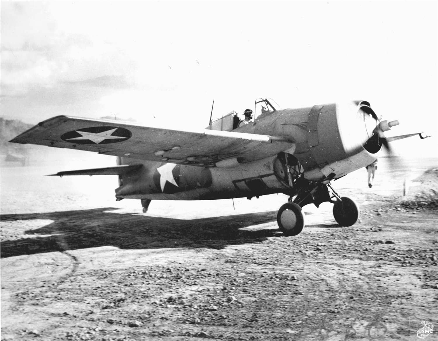 约1942年,瓜达尔卡纳尔岛上发动着引擎的一架F4F-4「野猫」战斗机。「瓜岛战役」中,「野猫」在酷热、疾病与补给匮乏的条件下坚持作战,凭借装甲与自封油箱扛住了零式的密集射击,许多遍体弹痕的战机仍能飞回亨德森机场,为后续F6F「地狱猫」的登场赢得了时间。