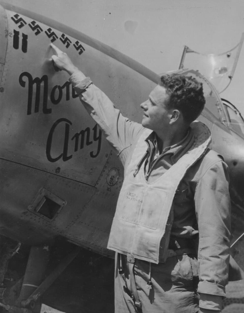 1944年6月26日,美军飞行员赫伯特·B·哈奇(Herbert B. Hatch)少尉手指他那架P-38座机上的五个「卐」字战绩标志。这些标志记录了他在普洛耶什蒂(Ploesti)突击行动中击落了五架纳粹德国军机。