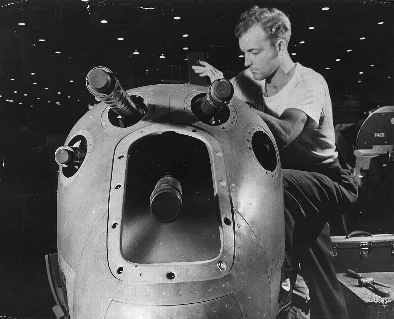 1942年,美国西部一家大型飞机制造厂的武器技师助手为P-38的机鼻位置安装机枪,P-38的武器一般包含1门20毫米机炮、以及4挺12.7毫米机枪。