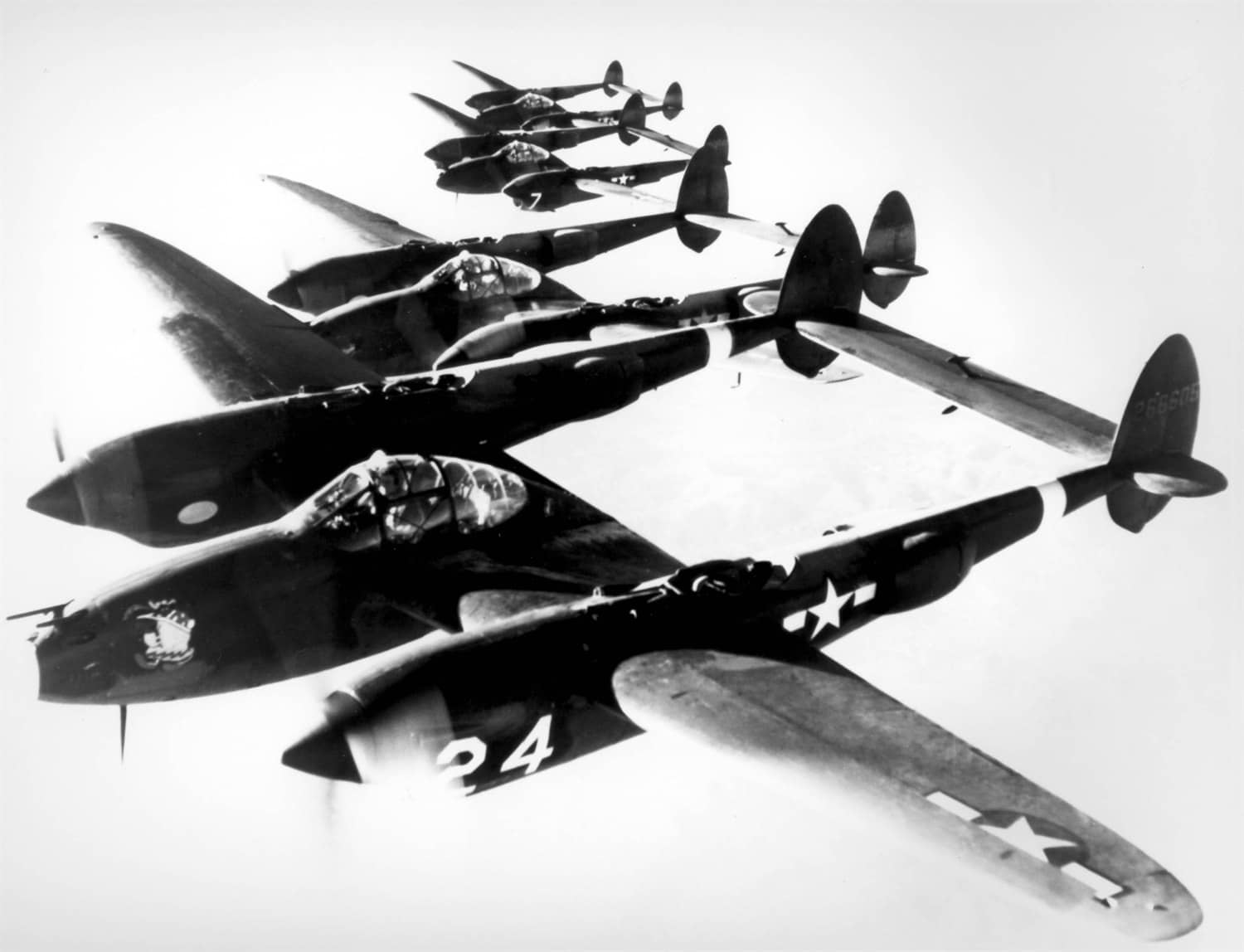 二战期间,四架密集编队飞行的P-38H「闪电」战斗机,其标志性的双尾撑布局、以及双发设计和涡轮增压器赋予了P-38卓越的航程和高速性能,使其成为太平洋战场美军头号王牌座机。