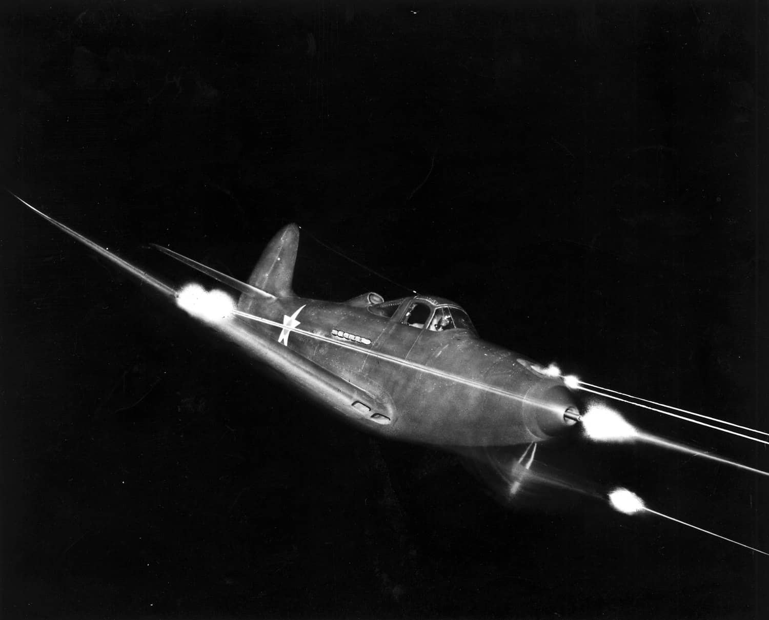 美国陆军航空队发布的P-39夜间全武器开火试验照片,其机头部位的37毫米M4机炮与两挺12.7毫米机枪全部集中布置,是P-39区别于同期战斗机的显著特征。