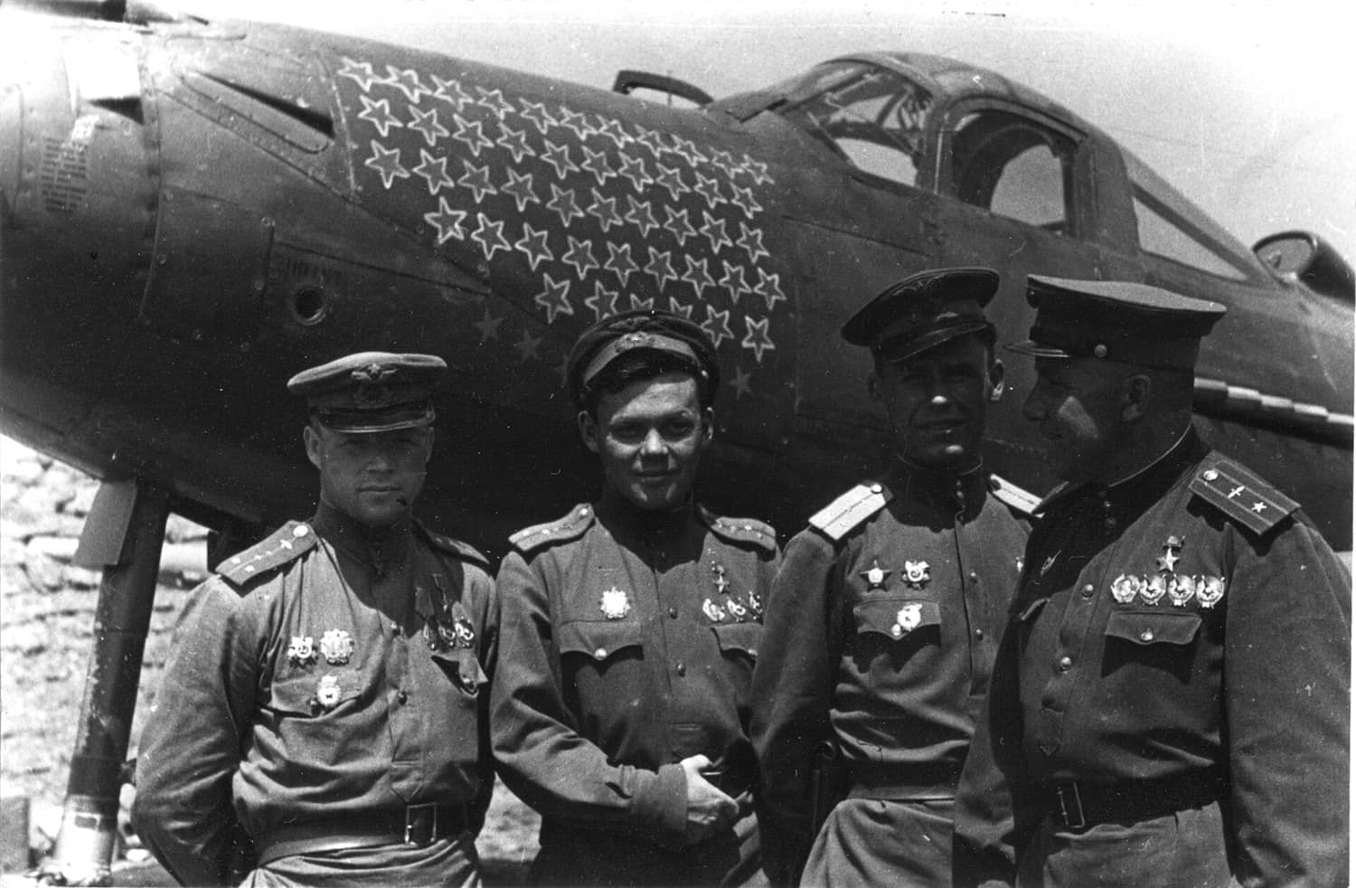 1944年6月,乌克兰第2方面军,第9近卫歼击航空兵师王牌飞行员在雷恰洛夫的P-39前合影,左起:克卢博夫、雷恰洛夫、特鲁德与第16近卫歼击航空兵团团长格利卡。该师是苏军驾驶P-39作战战绩最卓越的代表部队之一。