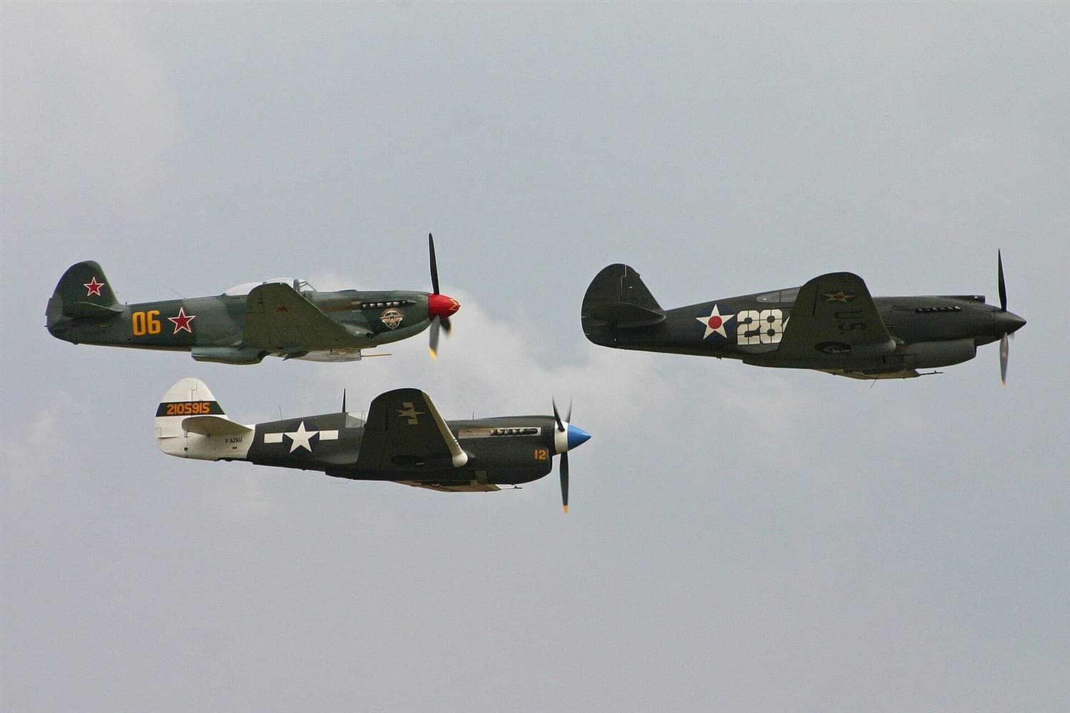2011年航展上,存世的P-40B(右)、P-40N「战鹰」(中下)与苏联雅克-9UM(左)战斗机编队飞行。战后仍有少量P-40被私人收藏家与博物馆保存至今。