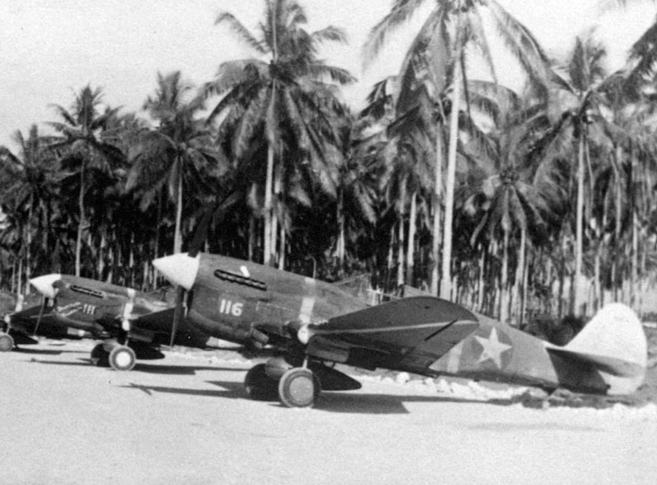 1943年中期,美国陆军航空队正逐步淘汰P-40F战斗机。图中距离最近的两架飞机为「白116号」和「白111号」,它们分别由亨利·E·马特森(Henry E. Matson)中尉和杰克·贝德(Jack Bade)中尉驾驶,这两位飞行员都是王牌飞行员,均隶属于驻扎在瓜达尔卡纳尔岛的第44战斗机中队。