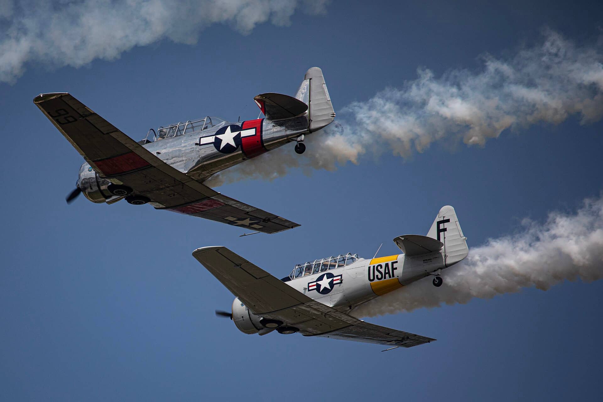 在威斯康星州奥什科什举办的2024年EAA奥什科什航空盛会(EAA AirVenture Oshkosh 2024)上进行拉烟表演的 T-6/AT-6「德州人」教练机。