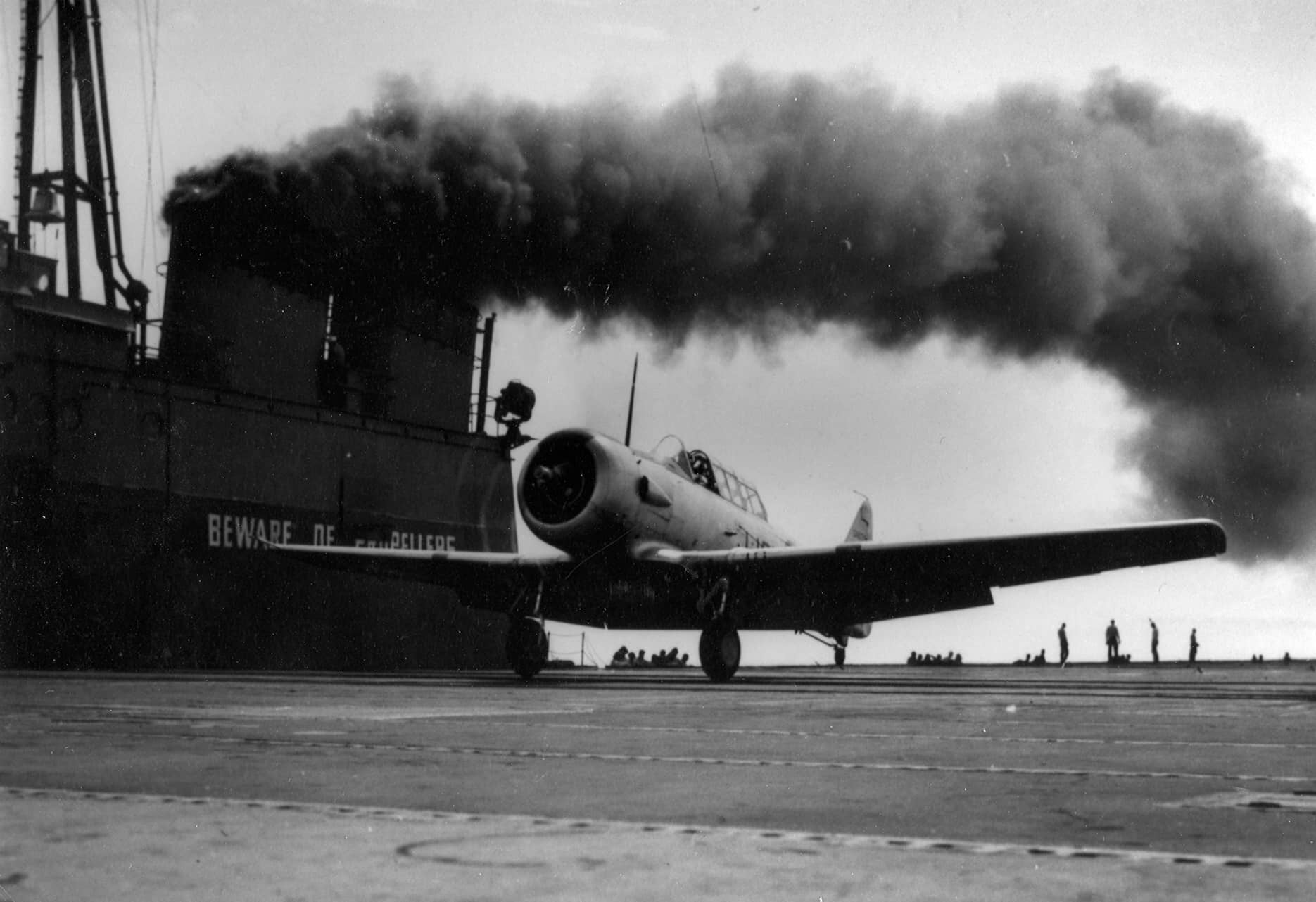 1945年,美国海军的一架 SNJ-5C「德州人」教练机停放在五大湖区的训练航母「塞布尔」号(USS Sable,IX-81)飞行甲板上。注:塞布尔号与姊妹舰「狼獾」号是二战期间美国海军在五大湖淡水区使用的改装训练航母,为海军飞行员进行航母着舰资格训练,SNJ-5C 是加装着舰尾钩的 SNJ-5 改型。