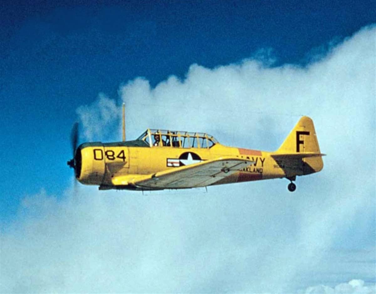 约1950年,一架隶属于加利福尼亚州奥克兰海军航空站(NAS Oakland)的 SNJ-5「德州人」教练机(机身编号084)在训练飞行中,机徽与「NAVY」「OAKLAND」字样清晰可见。注:1950年正值朝鲜战争爆发,该基地训练任务激增,SNJ 仍是海军标准教练机。