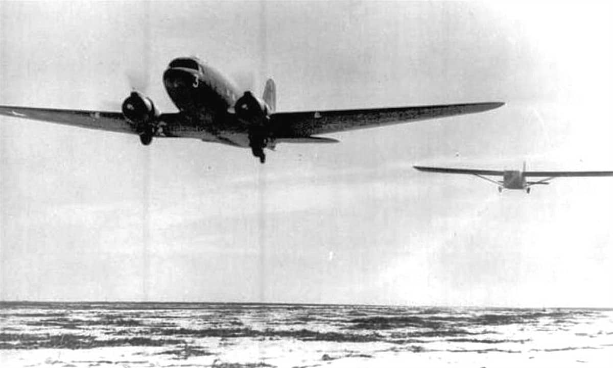 二战期间，美国得克萨斯州达尔哈特陆军机场，一架 C-47「空中列车」运输机正在拖曳 CG-4A「哈德良」滑翔机进行编队牵引训练。注：该基地是美国陆军航空队的滑翔机飞行员训练基地之一，为「西西里战役」「霸王行动」等大规模空降作战培养机组。