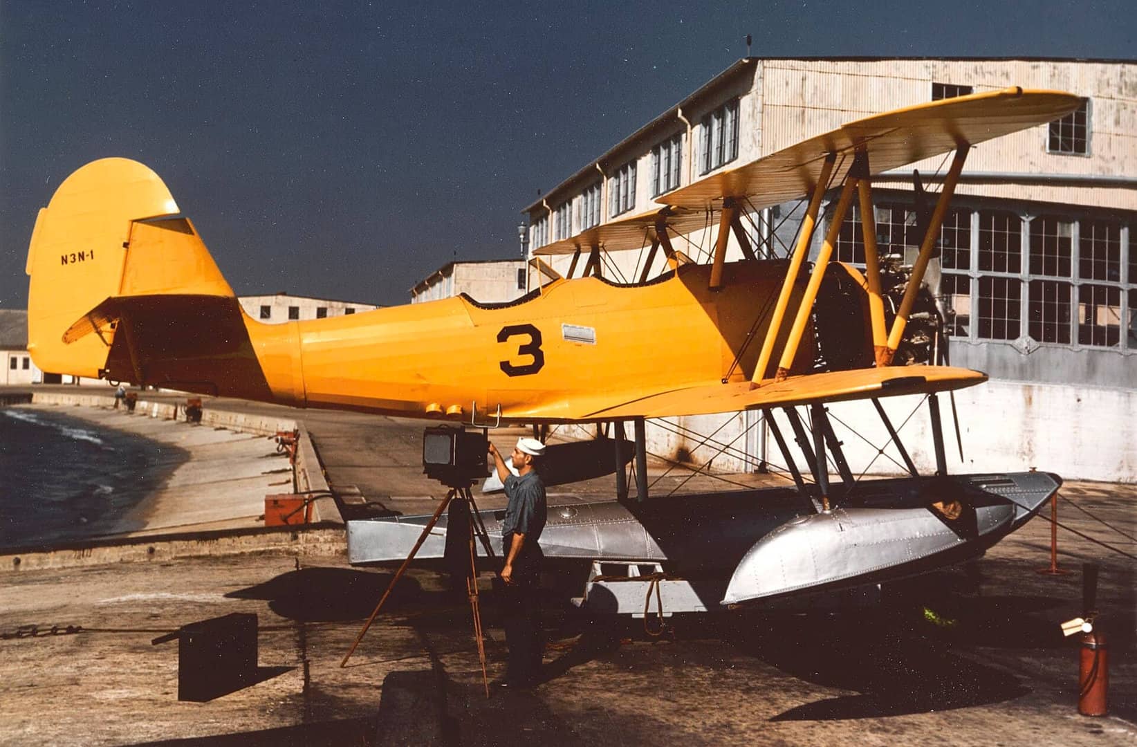 1942年间,一架停放在佛罗里达州彭萨科拉海军航空站(NAS Pensacola)水上飞机坡道上的美国海军 N3N「金丝雀」初级教练机。该机发动机后方的机身蒙皮已被拆除,以便进行维护作业。注:这架飞机就是编号「BuNo 0265」、历史上唯一一架的 XN3N-2 试验机。但此刻它安装了 N3N-1 型的尾翼方向舵以及用于水上起降的浮筒。