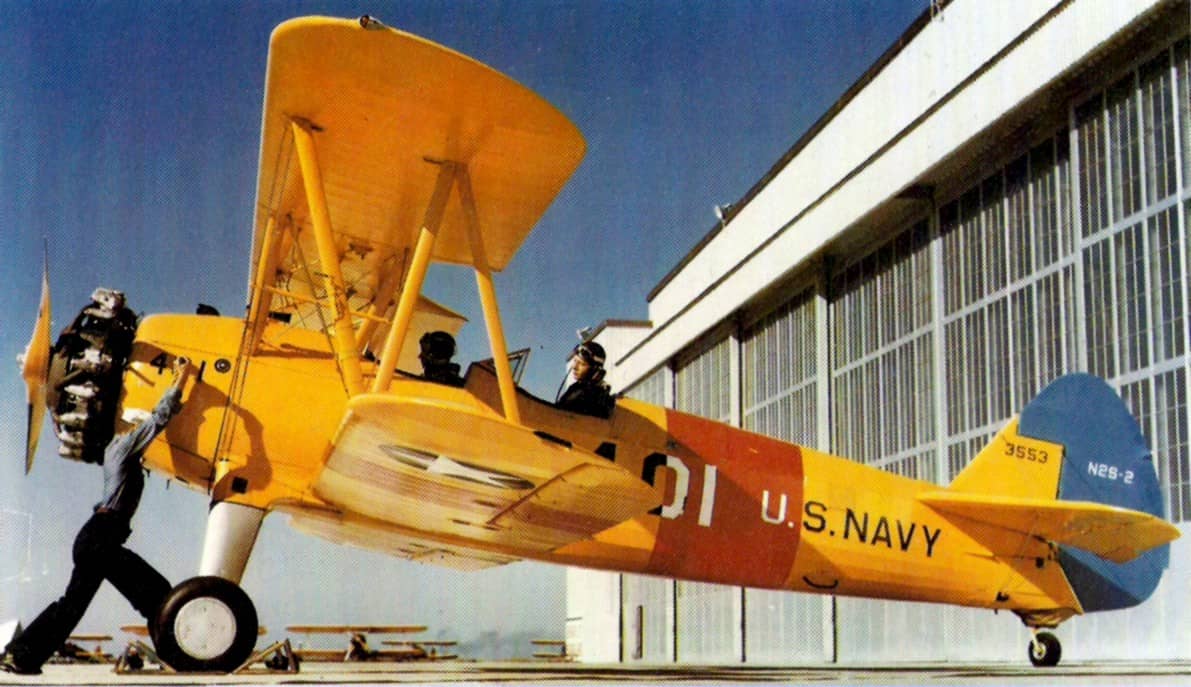 1943年，美国德克萨斯州科珀斯克里斯蒂海军航空站，一名美国海军士兵正在摇转一架斯蒂尔曼 N2S-2「卡德特」教练机（编号：BuNo 3553）的发动机。注：手摇螺旋桨是星形发动机教练机在无电力起动设备时的标准起动方式。