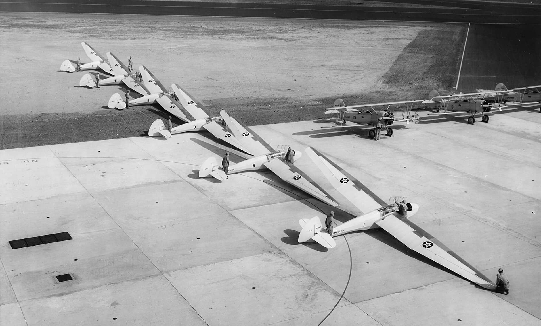 1942年5月,南卡罗来纳州帕里斯岛佩奇机场,美国海军陆战队的 LNS-1 滑翔机(施韦策 SGS 2-8 / TG-2 海军型)整齐排列,后方可见担任拖曳任务的 N3N「金丝雀」教练机。
