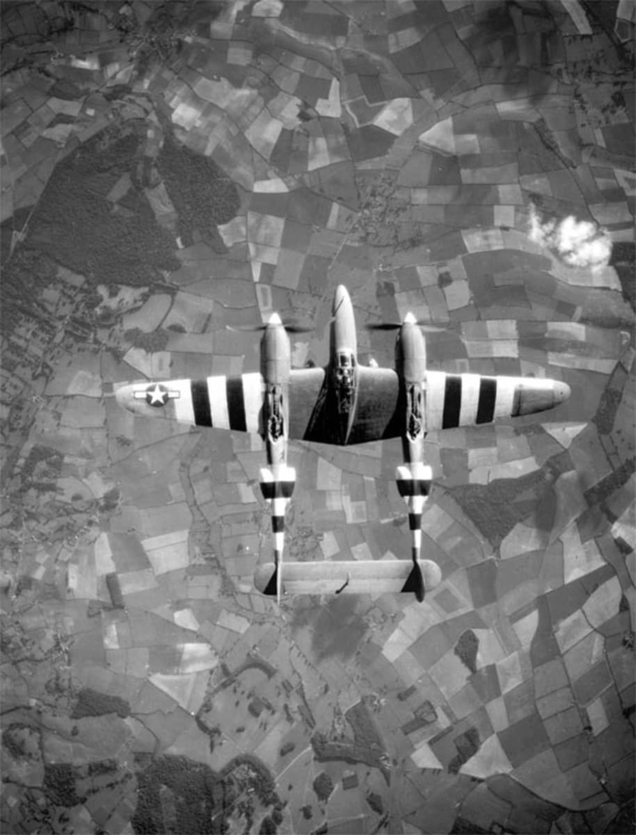 洛克希德F-5「闪电」侦察机在英国乡村上空飞行,其机身机翼上的「黑白入侵」条纹清晰可见。注:这幅照片由另一架「闪电」侦察机上安装的垂直相机拍摄。