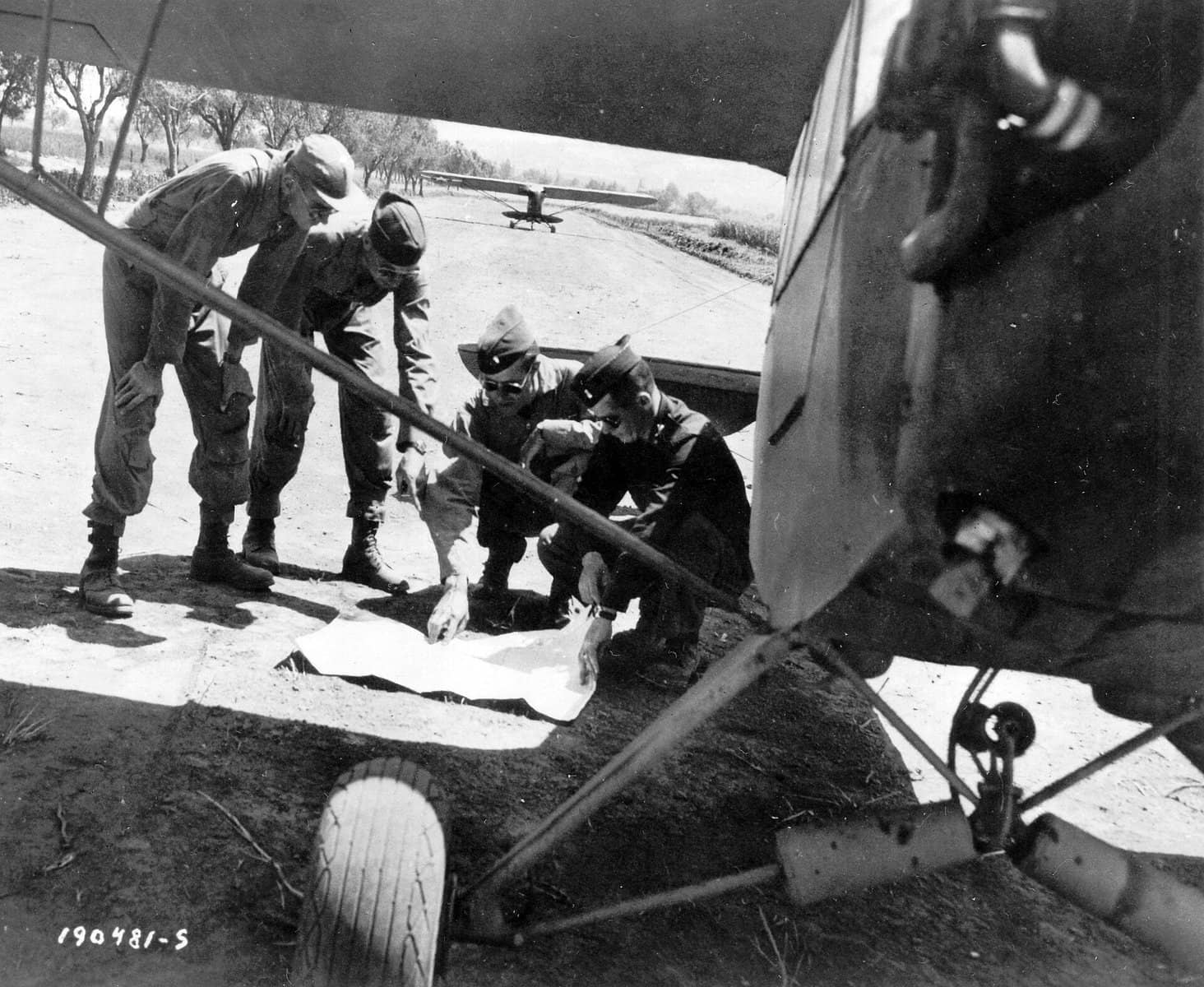 1944年5月15日,意大利塞萨(Sessa)地区,几名「蚱蜢」飞行员正围在铺开的地图前进行任务简报,身后即是待命的L-4联络机。