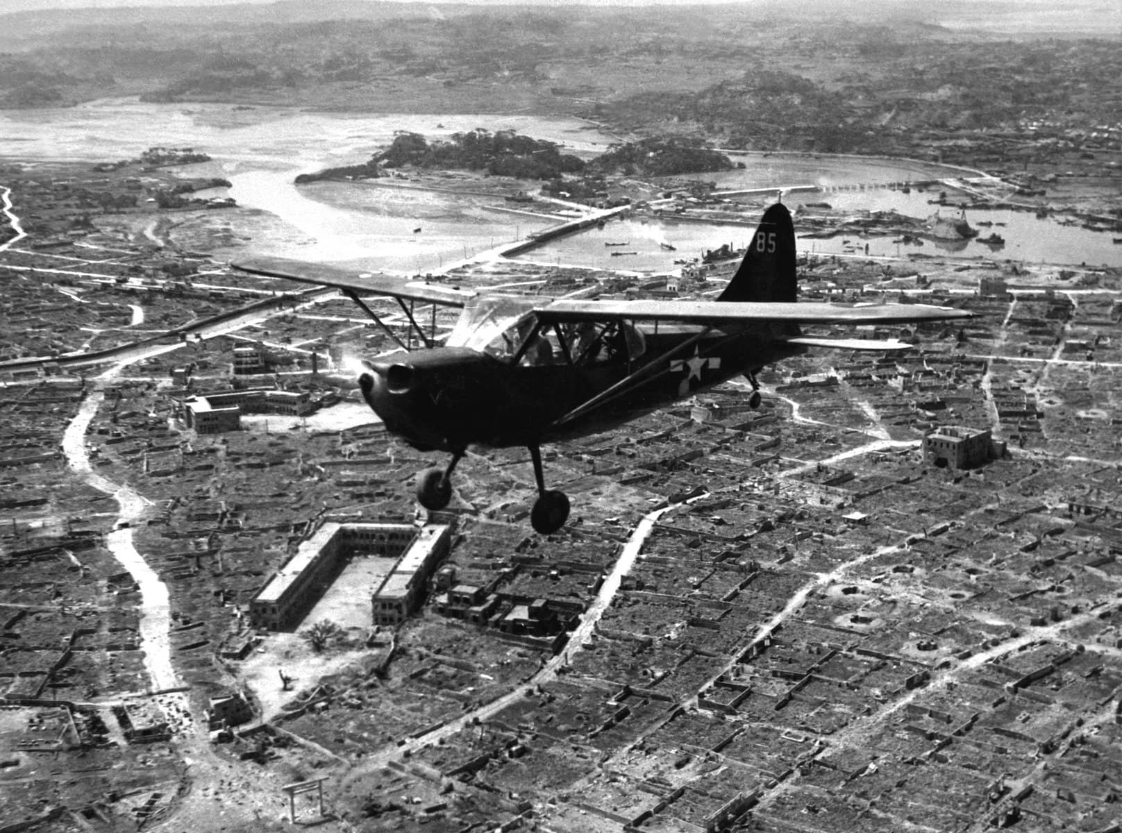 1945年5月前后,一架美国海军陆战队的斯廷森OY-1「哨兵」观测机低空飞越冲绳首府那霸上空。在此次飞行中,该机遭到了城内日军的轻武器及防空火力射击。注:OY-1是L-5的海军陆战队观测型号,陆战队在太平洋战场广泛使用其执行炮兵校射与联络任务。