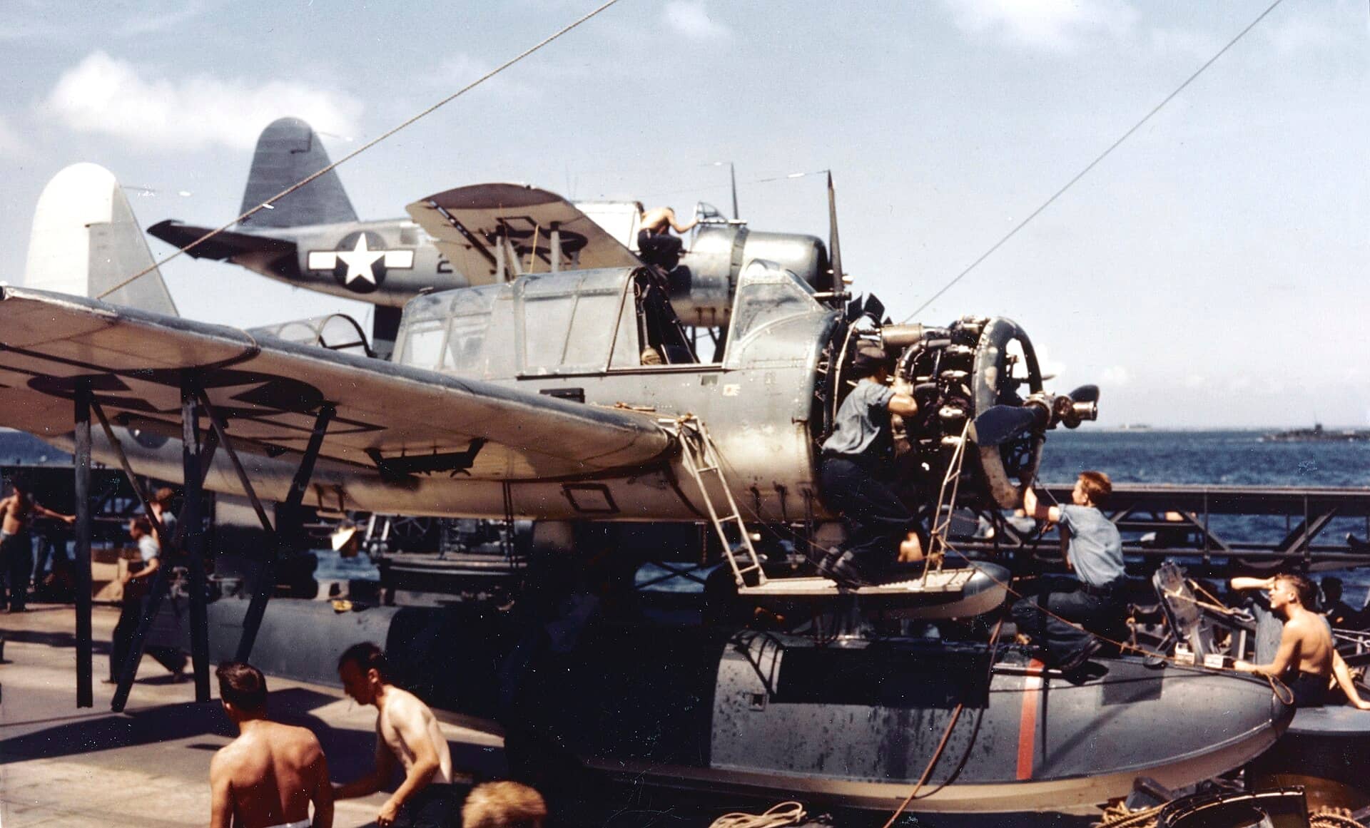 1944年，南达科他号战列舰（BB-57）甲板上，地勤人员正在维护一架OS2U「翠鸟」。战列舰弹射侦察机通常编为2至3架一组，随舰整备待命。