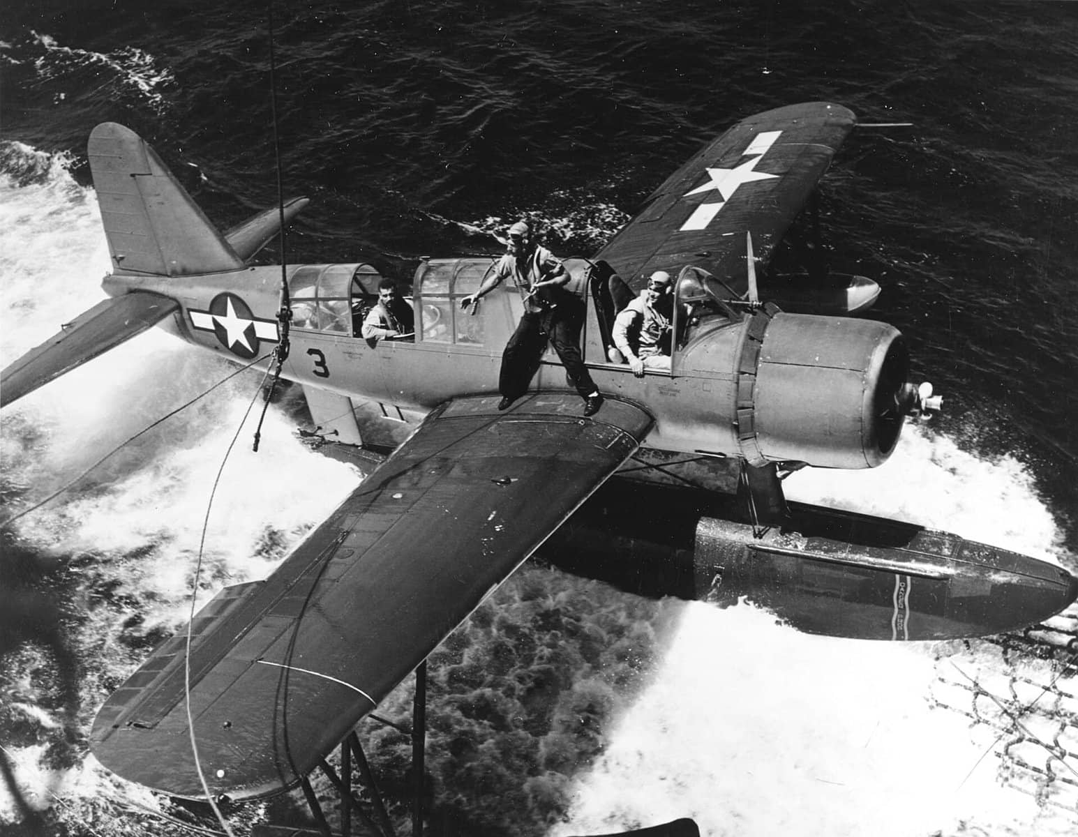 1944年2月18日，「巴尔的摩」号重巡洋舰（CA-68）在特鲁克群岛外海回收一架OS2U-3「翠鸟」水上飞机。此时美军正在执行对特鲁克的「冰雹行动」空袭，翠鸟在战斗间隙完成侦察返航回收。