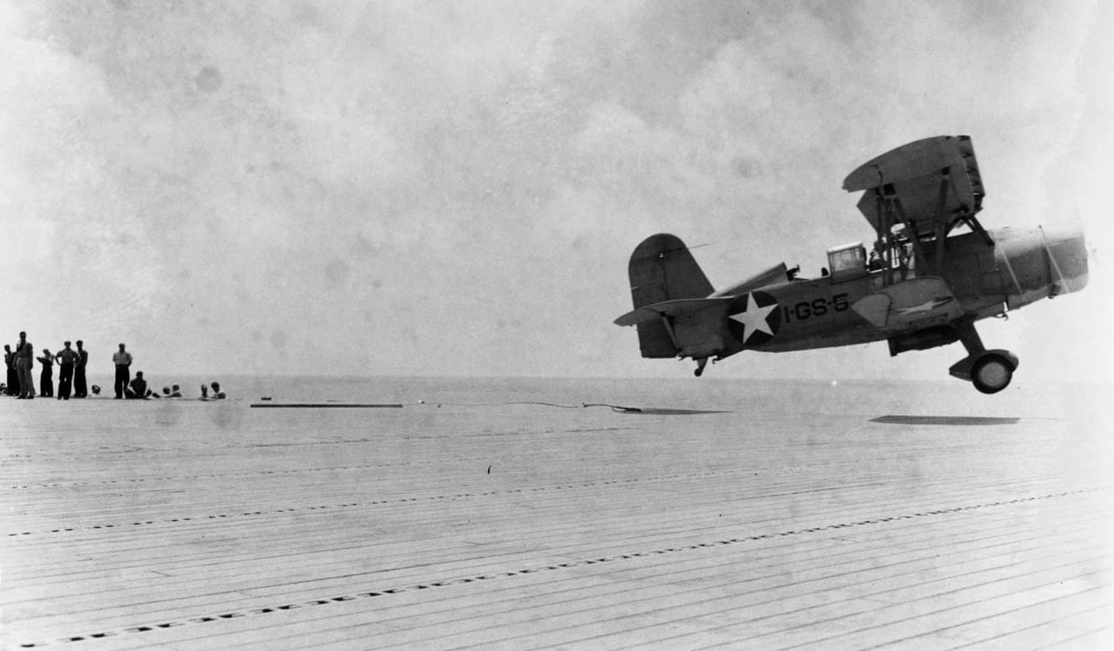 1942年5月21日,护航航母长岛号(AVG-1)上,一架SOC-3A「海鸥」正沿斜跨飞行甲板的弹射器起飞执行反潜巡逻。此前数日太平洋战场刚结束「珊瑚海海战」,大西洋上的长岛号以海鸥护航运输船队。