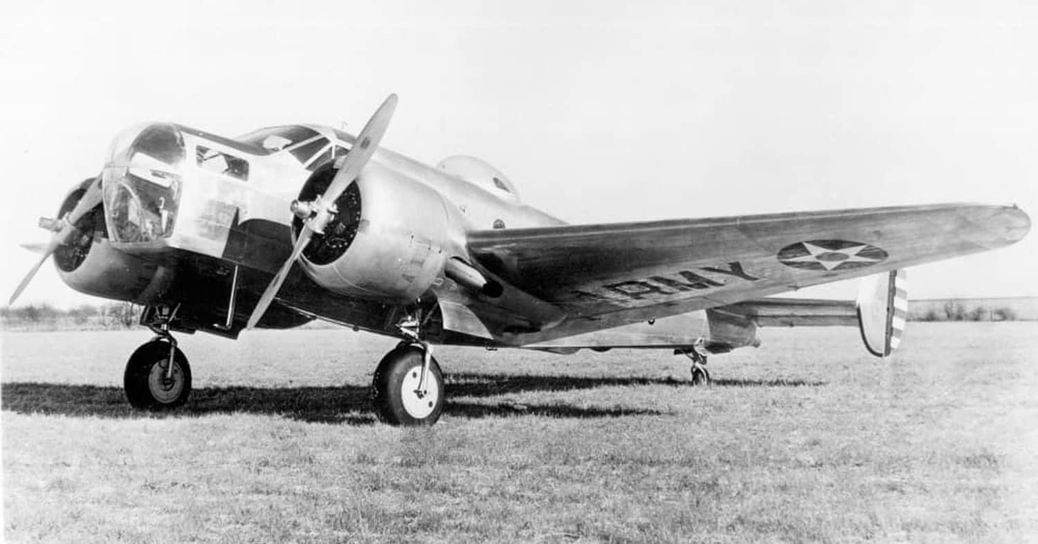 二战期间,美国陆军航空队的一架 AT-11「堪萨斯人」教练机停放在机场,机翼上可见美国陆军航空队的白星机徽与「ARMY」字样标识。