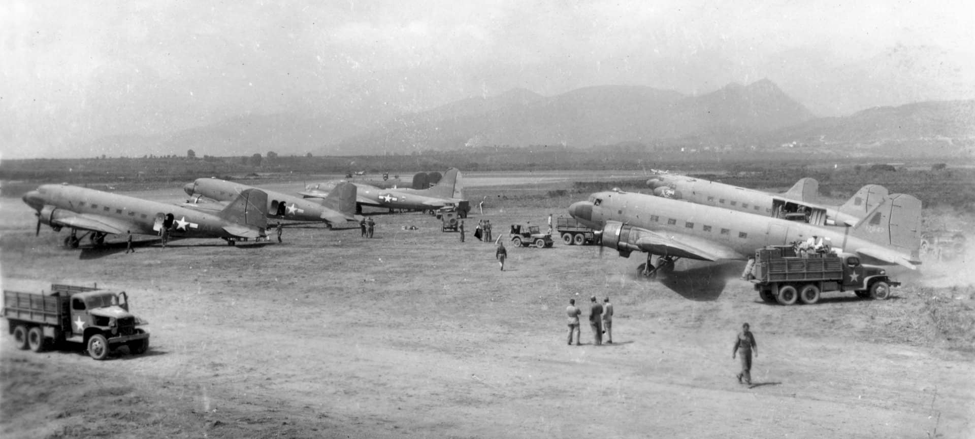 1944年5月28日,法国科西嘉岛吉索纳恰-阿尔齐托内机场(Aérodrome de Ghisonaccia Alzitone)停机坪上的场景,其中图片右侧近处那架编号为「41-7847」的C-47-DL型「空中列车」运输机(被卡车遮挡了部分后机身)用于运送美国陆军航空队第52战斗机大队的地勤人员和物资。