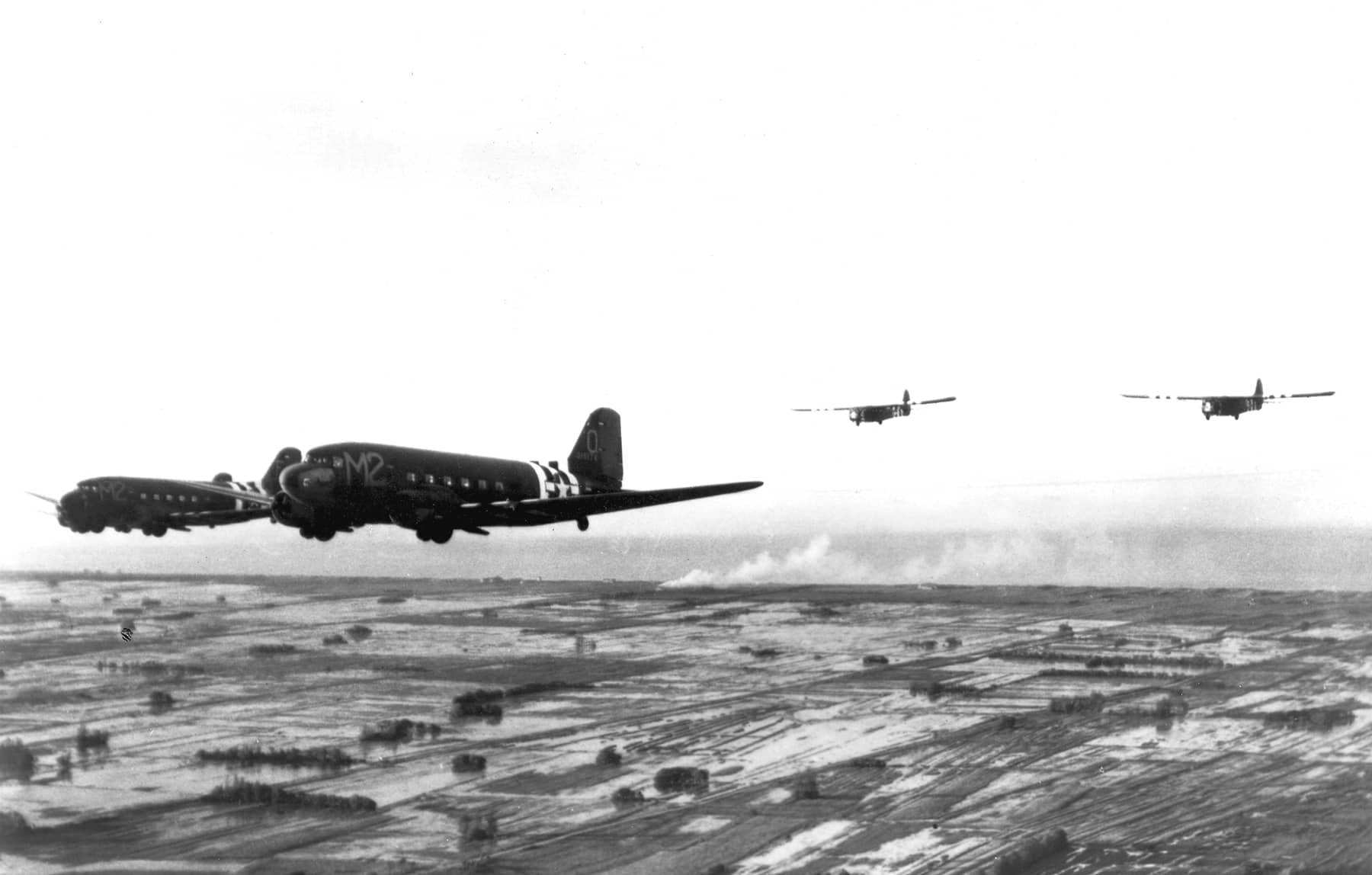 1944年6月,诺曼底登陆期间,隶属于美国陆军航空队第9运输机司令部第53运输机联队第438运输机大队第88运输机中队的道格拉斯C-47「空中列车」运输机(领头机编号:43-15174)拖曳瓦科(Waco)CG-4A型滑翔机执行增援任务。注:1944年6月6日午夜刚过,该中队在法国卡朗唐(Carentan)西北地区空投了第101空降师第502伞降步兵团。随后,该中队执行了滑翔机增援任务,运送了武器、弹药、口粮及其他补给物资。