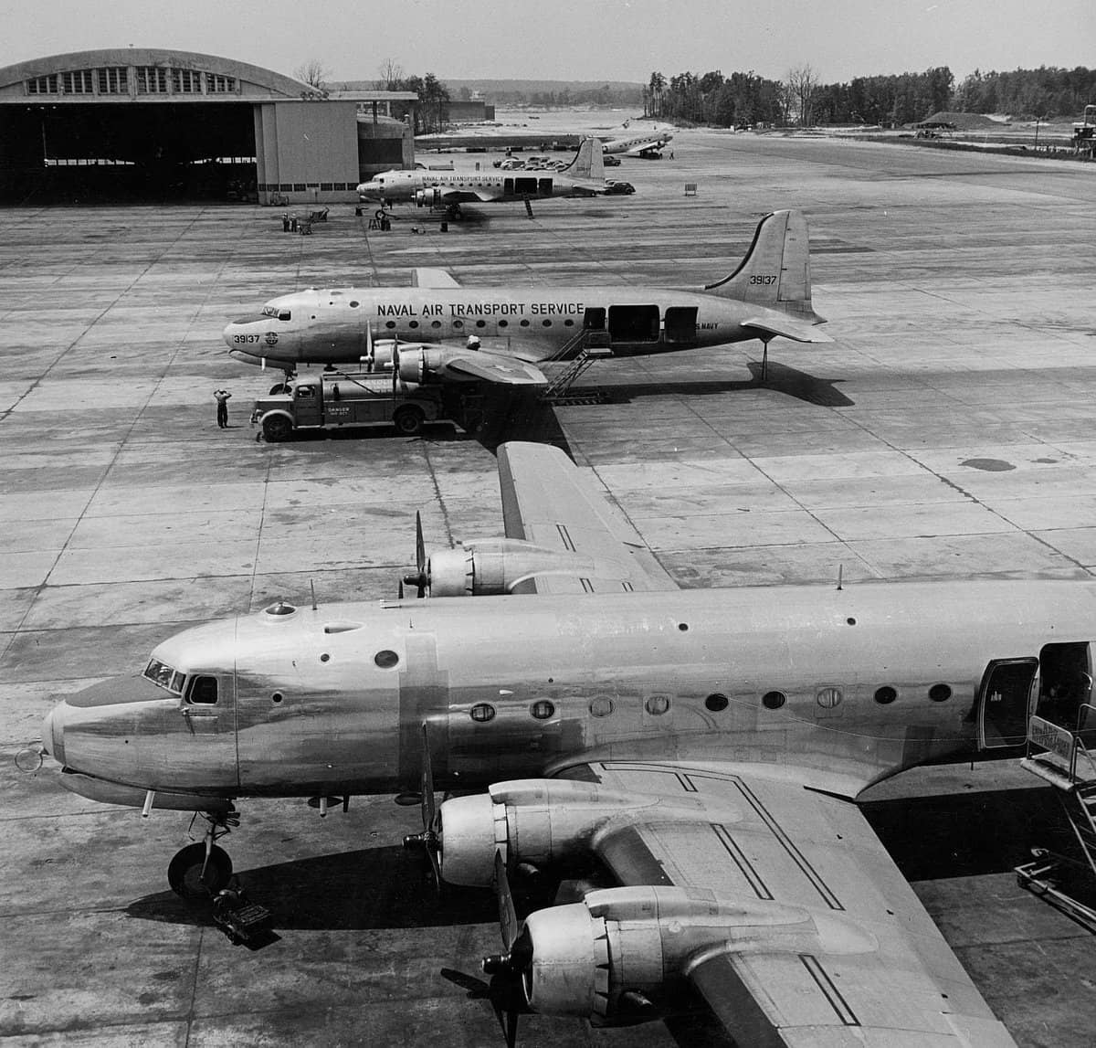 1945年前后,停放在某处航空站停机坪上的美国海军道格拉斯 R5D-1「空中霸王」运输机,其中两架带有海军航空运输勤务队(NATS)的标识;位于中间的那架飞机是交付给美国海军的首架 R5D-1。
