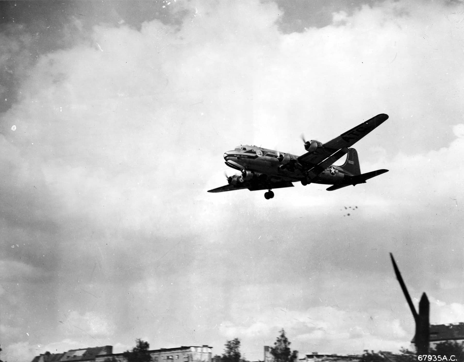 「柏林空运」期间(1948-1949年),一架 C-54 在柏林城市上空投下系着自制降落伞的糖果包裹,这是「小葡萄干行动」的一部分。飞行员哈尔沃尔森中尉发起的糖果空投成为西柏林儿童的希望象征。