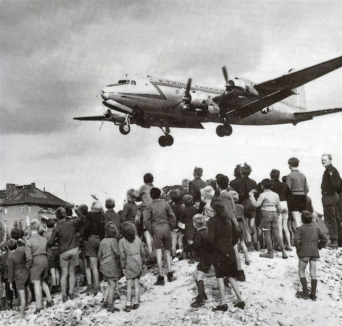 「柏林空运」期间,一架 C-54 正低空进近柏林滕珀尔霍夫机场准备降落。C-54 与 C-47 共同构成空运主力,在西柏林被封锁的11个月里投送了超过230万吨物资。其中 C-54 凭借四发布局与巨大载量,成为空运行动后期的主力机型,创造了单日投送量的纪录。