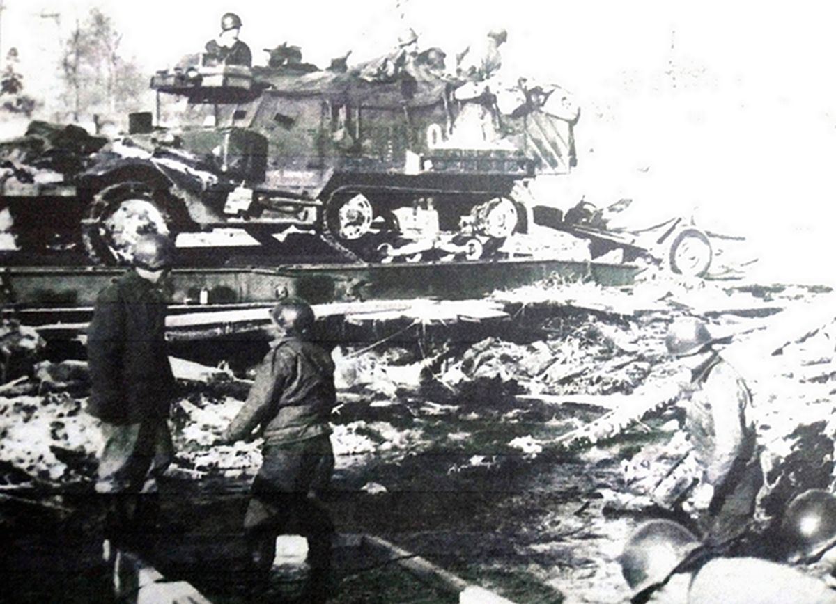 1945年1月,「阿登反击战」期间,美军第49战斗工兵营的一辆M2A1半履带装甲车牵引着一门37毫米M3反坦克炮驶上路轨。