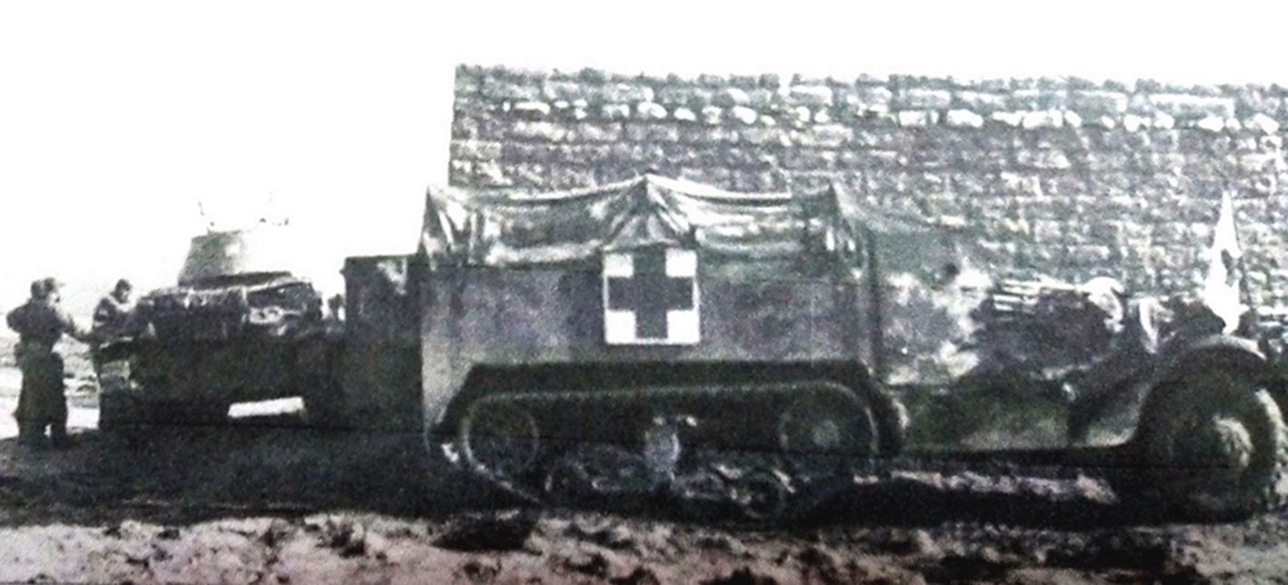 1943年2月,「突尼斯战役」期间,停靠在突尼斯凯赛林隘口(Kasserine Pass)地区的美军第1装甲师一辆M3半履带装甲救护车。图左侧是一辆已废弃的意大利M-13/40战车。