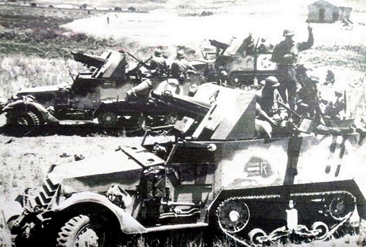 1943年7月，「西西里岛战役」期间，登陆西西里岛利卡塔地区的美军装甲炮兵营T30半履带装甲车的特写镜头。外侧的半履带车车身侧面有一个识别作战单位的三个彩条标记（彩条颜色为上下条为浅灰色，中间一条为蓝色），并有一个「2651-R」代码。