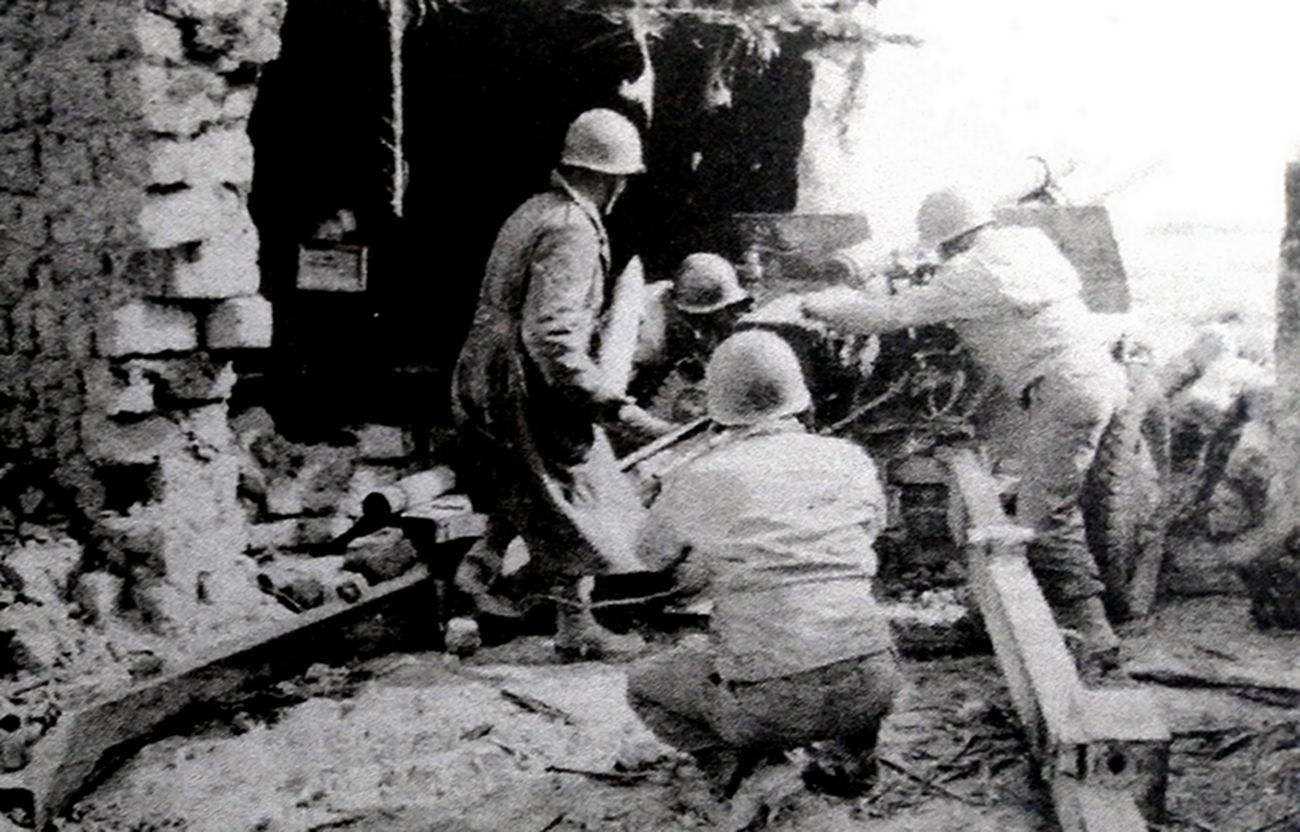 1943年2月，「卡塞林山口战役」期间，美军第33野战炮兵营的一门M2（M101）式105毫米榴弹炮在卡塞林山口附近为美军步兵提供火力支援。