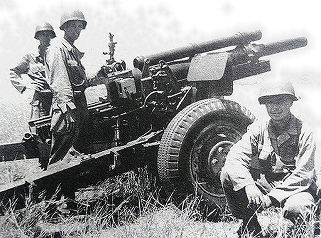 战斗间隙中，几名美军炮兵与一门M2（M101）式105毫米榴弹炮的合影。