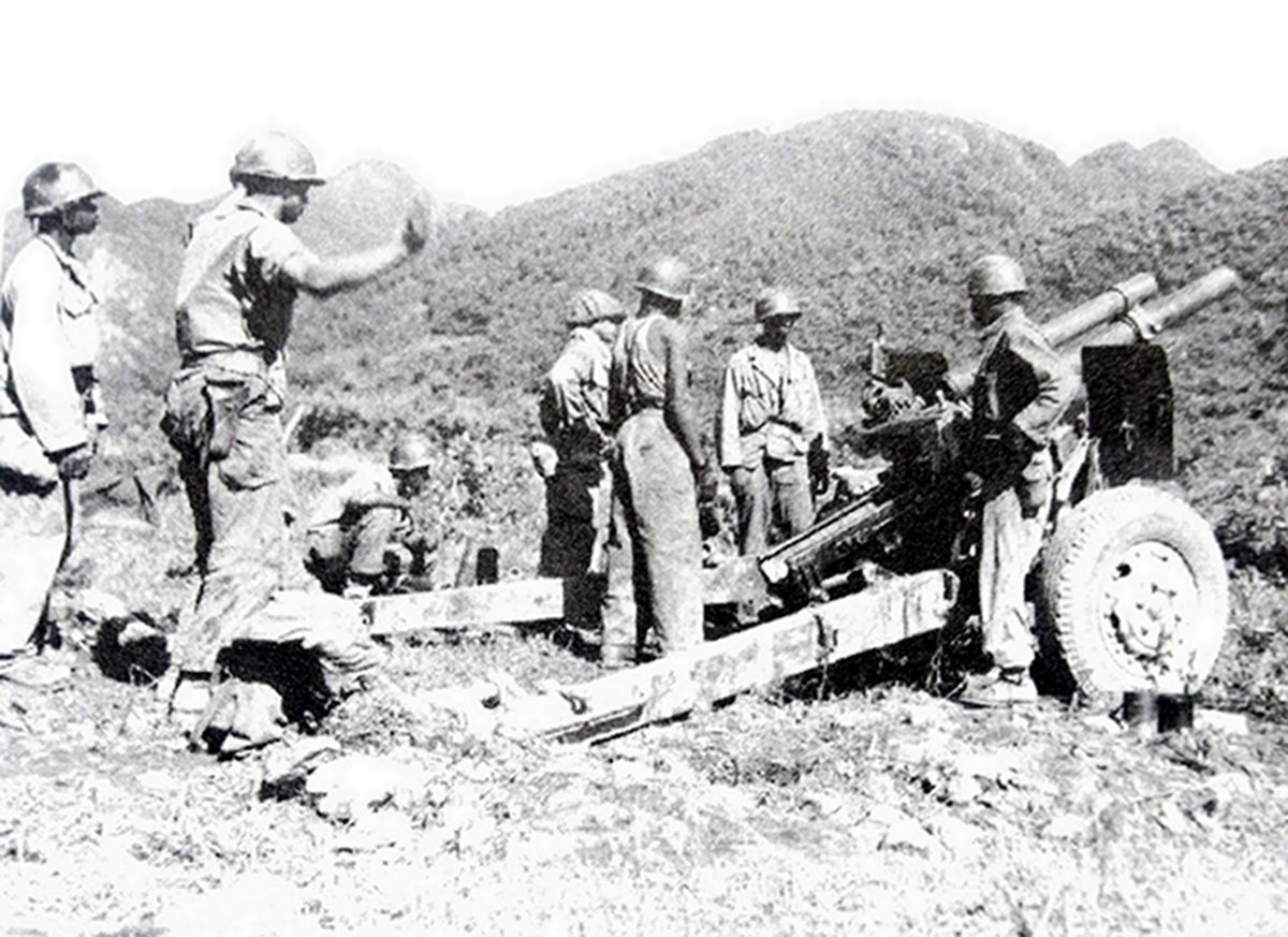 二战战场上，一处美军M2（M101）式105毫米榴弹炮阵地上，士兵们正在炮长指挥下调整火炮射击角度。