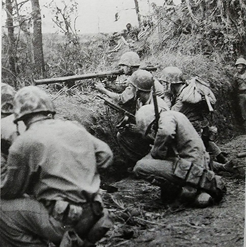 1945年，「冲绳岛战役」期间，太平洋战场冲绳岛，美陆军士兵正在使用一支M9A1型「巴祖卡」火箭发射筒瞄准日军工事，随时准备进行攻击。
