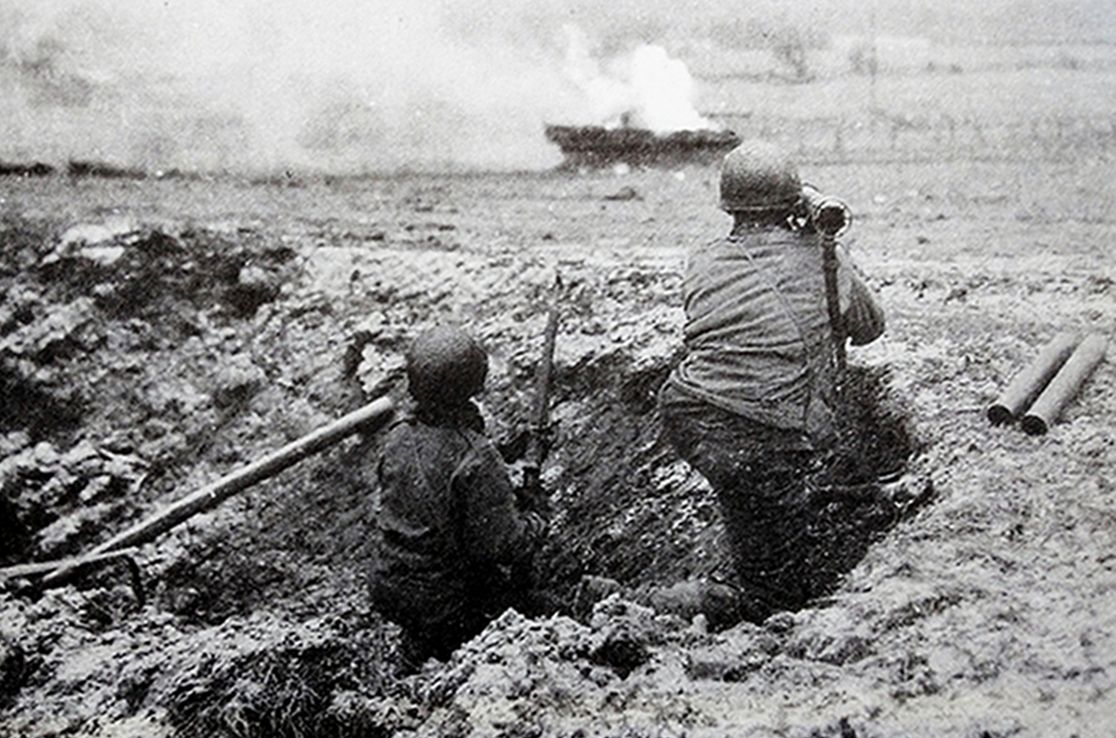 1944年12月，西线战场，美军一个火箭筒小组持M1A1型「巴祖卡」火箭发射筒击毁了德军一辆黑豹坦克。